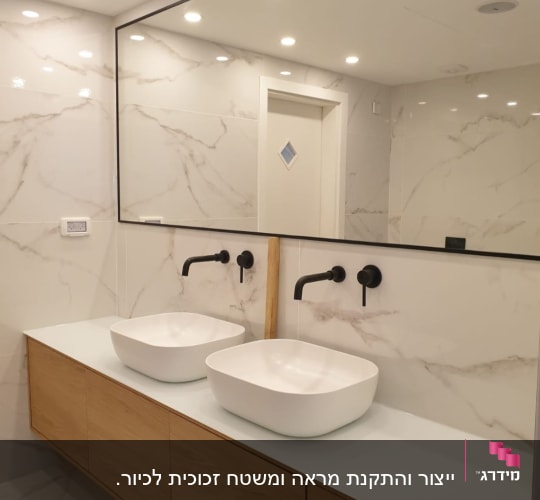 מראה גדולה עם מסגרת שחורה בחדר אמבטיה מודרני